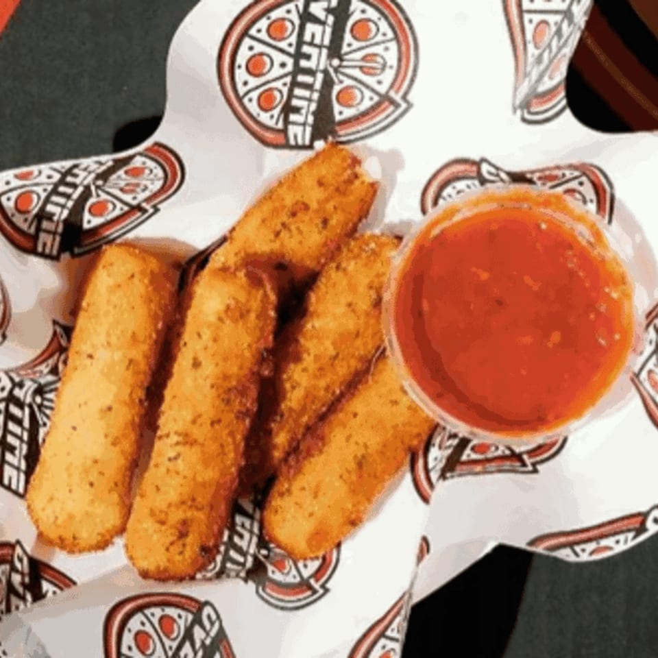 Golden-brown mozzarella sticks and a side of red marinara sauce on Overtime Pizza branded paper.